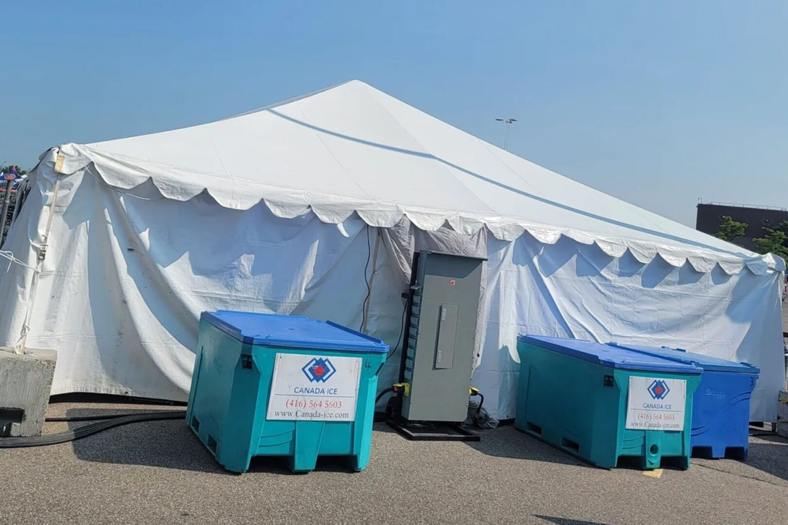 A tent with two blue boxes on the ground