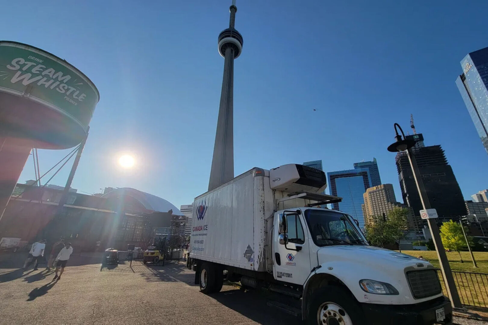 A white truck parked in front of the cn tower.