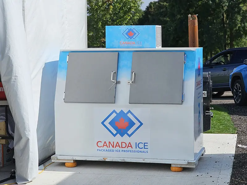 A large ice machine sitting outside on the sidewalk.